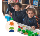 Dos niños pequeños muy felices sonriendo, mientras juegan con unas fichas y bloques armables.