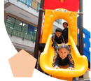 Tes niños pequeños jugando en un rodadero.