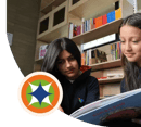 Dos jóvenes estudiantes mujeres leyendo con atención en el aula de clases.