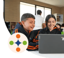 Niño y niña sonriendo mientras están interactuando con una laptop.